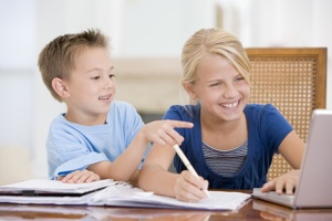 Девочка с младшим братом делает уроки