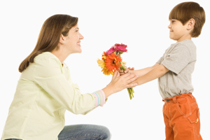 Мальчик дарит маме цветы