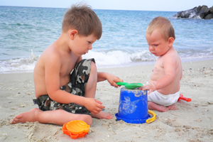 Дети играют с песком на берегу моря