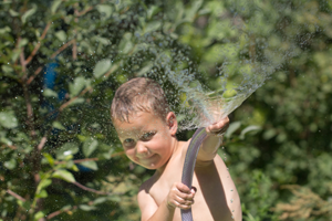 Мальчик играет с водой на природе