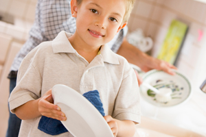 Мальчик помогает мыть посуду